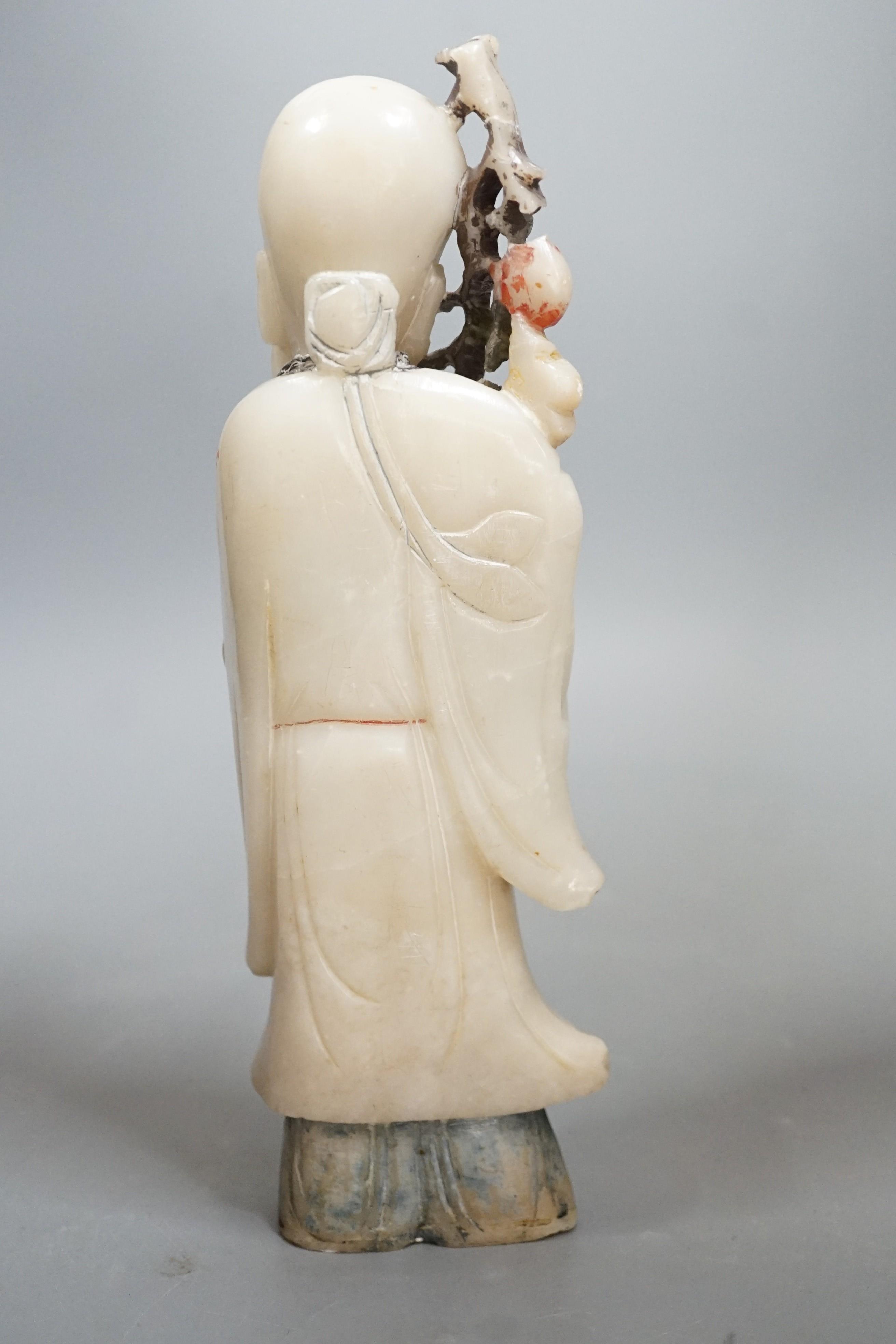 An 18th century Chinese carved soapstone figure of Shao Lou on carved hardwood stand. 24cm high (a.f.)